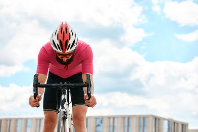 Rear view of man riding bicycle against sky