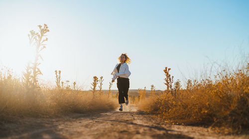 Woman standing on field against clear sky