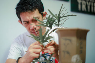 Side view of man holding potted plant
