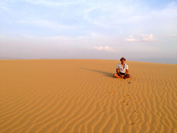 Scenic view of man on desert against sky