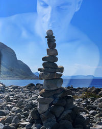 Stack of stones on beach against sky