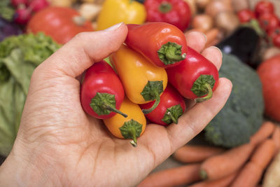 Close-up of hand holding red bell peppers