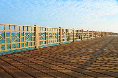 A wooden pier on the shores of the red sea with a horizon in the background.