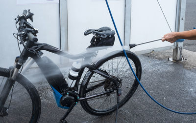 Midsection of man holding bicycle in city