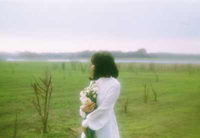 Rear view of woman standing on field