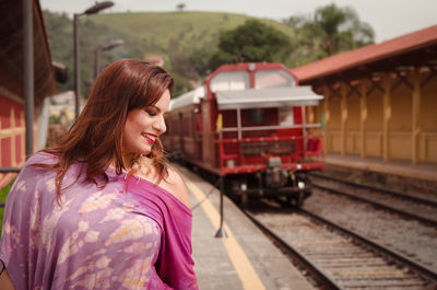 Close-up of woman with train at railroad station