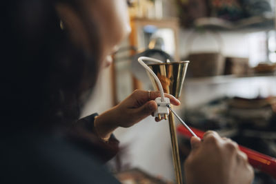 Female entrepreneur repairing electric socket at antique store