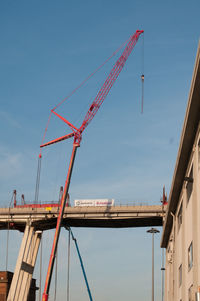 Low angle view of cranes against sky