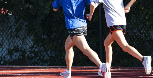 Low section of people running on sports track