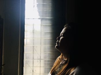 Side view of woman with closed eyes in darkroom