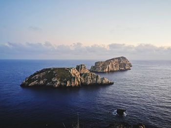 Scenic view of rock formation in sea against sky