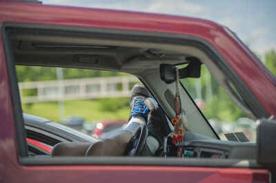 Close-up of man on side-view mirror of car