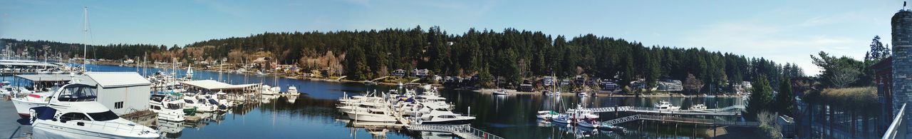 Panoramic view of boats moored in lake against sky