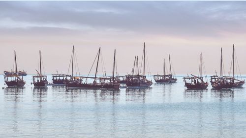 Sailboats in sea against sky