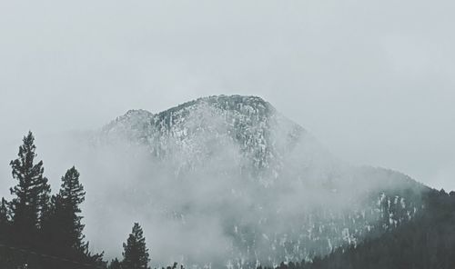 Low angle view of snowcapped mountains against sky