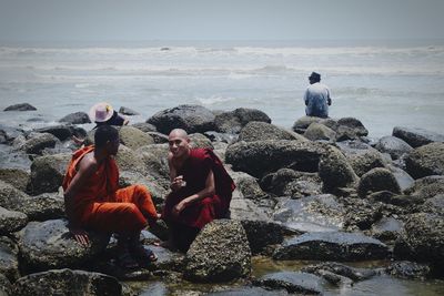 People at beach against sky