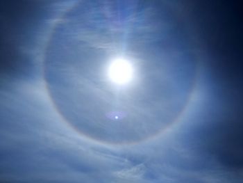 Low angle view of bright sun in sky
