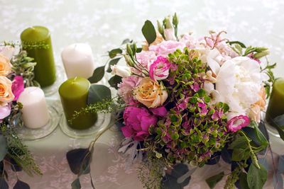 Wedding table setting with green candle and flowers