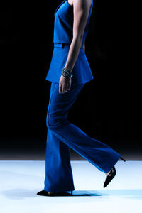 Classy blue outfit, pants and jacket, women's fashion cloth on black background with copy space