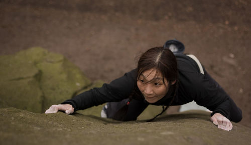 Woman bouldering on grid stone in the peak district / uk