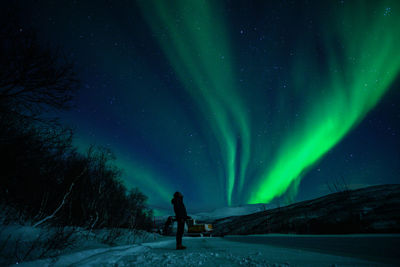 Full length of man standing on field against sky at night