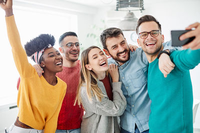 Smiling friends posing for selfie at home