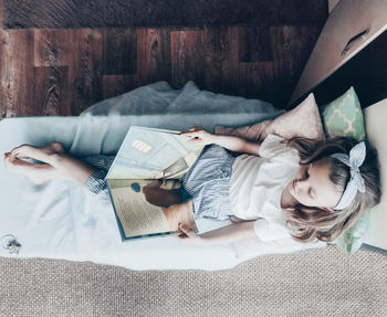 High angle view of woman lying on bed at home