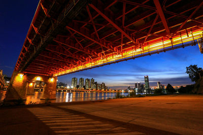 Illuminated bridge against sky at night