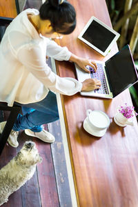 High angle view of woman using laptop on table at home