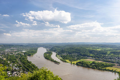 River rhein in western germany flowing along the city against the sky with clouds. visible ships.