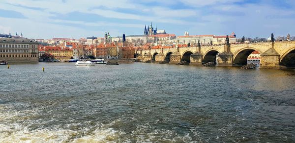 Bridge over river against buildings in city