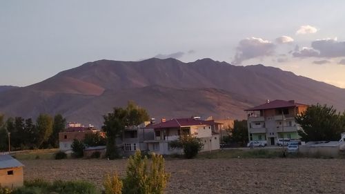 Houses by buildings against sky in city