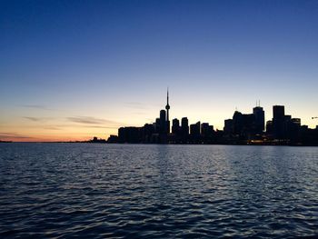 Silhouette of buildings in city during sunset