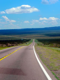 Road by landscape against sky