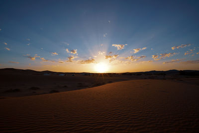 Scenic view of desert against sky during sunset