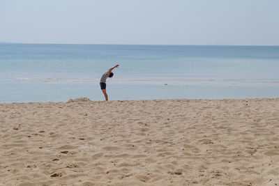 Woman on beach against sky