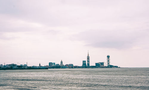 Buildings in city against cloudy sky