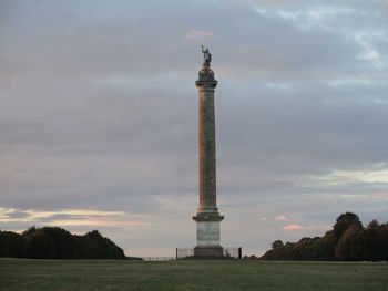 Low angle view of tower on field against sky