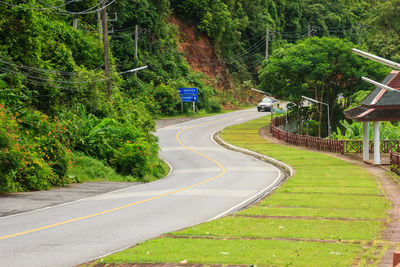 Road amidst trees against mountain