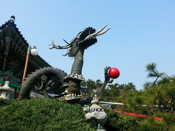 Low angle view of statue against clear blue sky