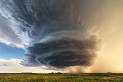 A supercell storm with ominous clouds spins over a field near malta, montana.