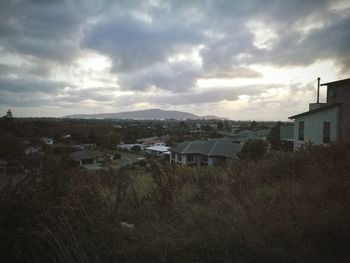 Houses in town against cloudy sky