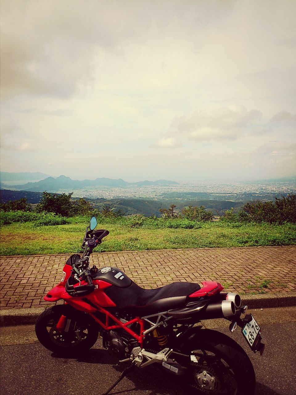 transportation, land vehicle, mode of transport, bicycle, parked, sky, stationary, parking, car, landscape, motorcycle, cloud - sky, travel, mountain, field, road, high angle view, day, outdoors, tranquility