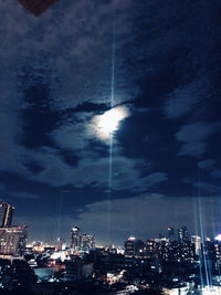 Illuminated buildings in city against sky at night