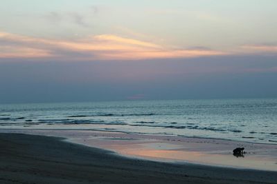 Scenic view of beach against dramatic sky