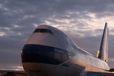 Airplane wing against sky during sunset