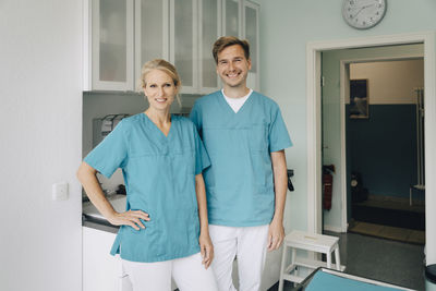 Portrait of smiling male and female animal experts standing in clinic