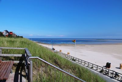 Scenic view of beach against blue sky