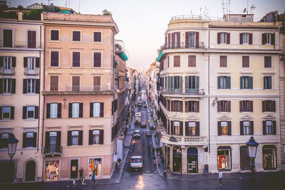 Buildings by street against sky in city