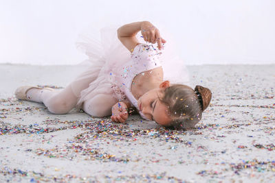 Tired girl lying on floor with multi colored confetti